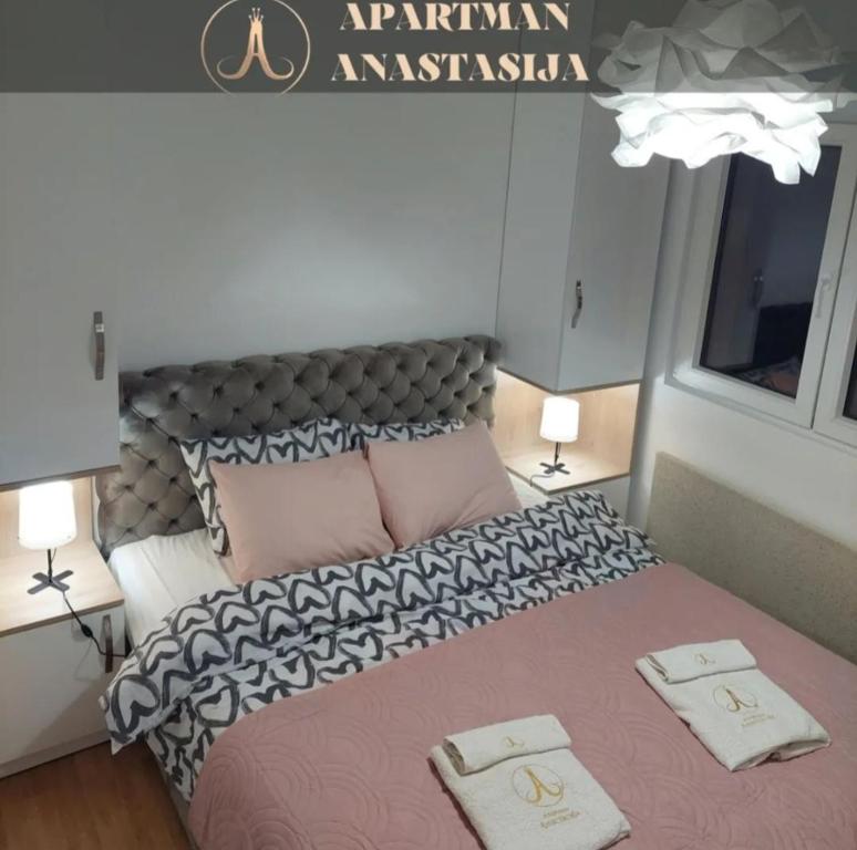 a bedroom with a large bed with two towels on it at Apartman Anastasija Vrnjačka Banja in Vrnjačka Banja