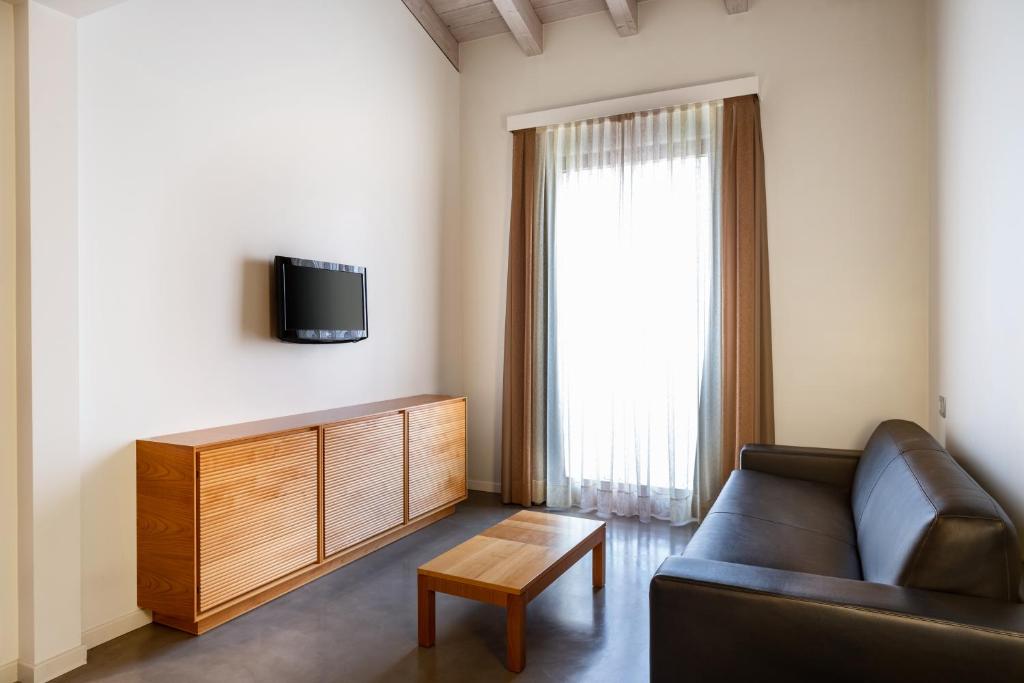 a living room with a couch and a tv at The Ziba Hotel & Spa in Peschiera del Garda