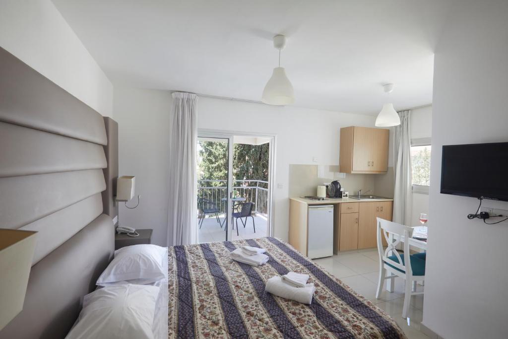 a bedroom with a bed and a kitchen with a table at Napa Nest in Ayia Napa