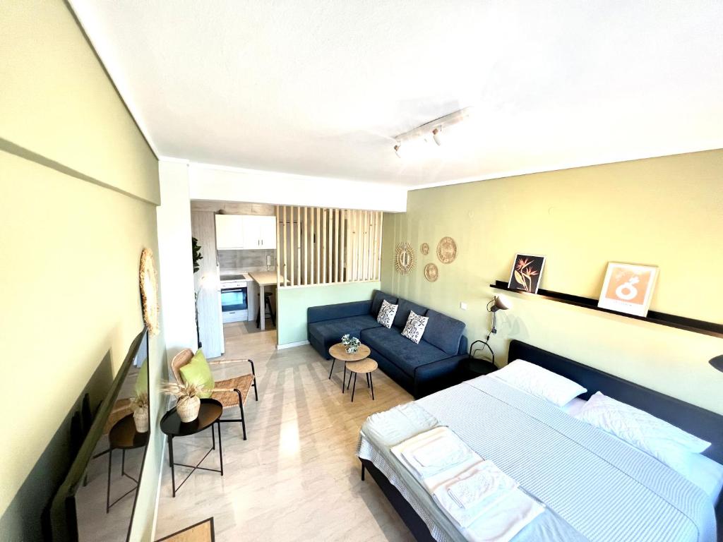 um quarto com uma cama azul e um sofá em Olive Apartment City Center by thesbnb em Tessalônica