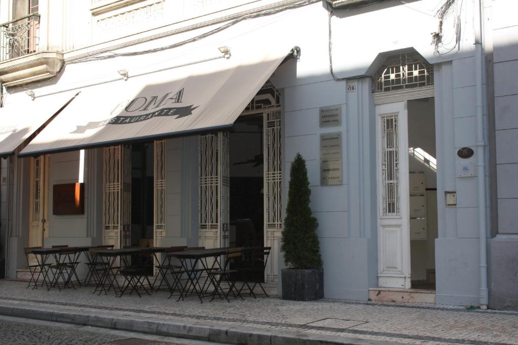 ein Gebäude mit einem Tisch und Stühlen davor in der Unterkunft Oporto Rivoli Apartments in Porto