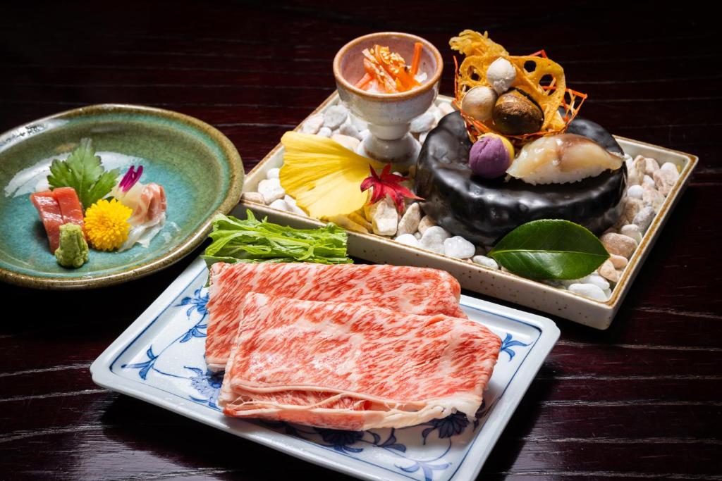 une table avec trois assiettes de nourriture dans l'établissement Hagi No Yado Tomoe, à Hagi