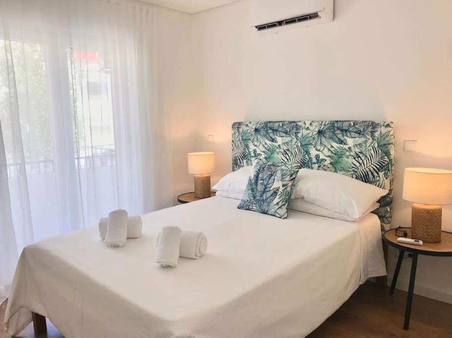 une chambre avec un grand lit blanc avec deux lampes dans l'établissement Casa do Sul Guest House, à Lagos