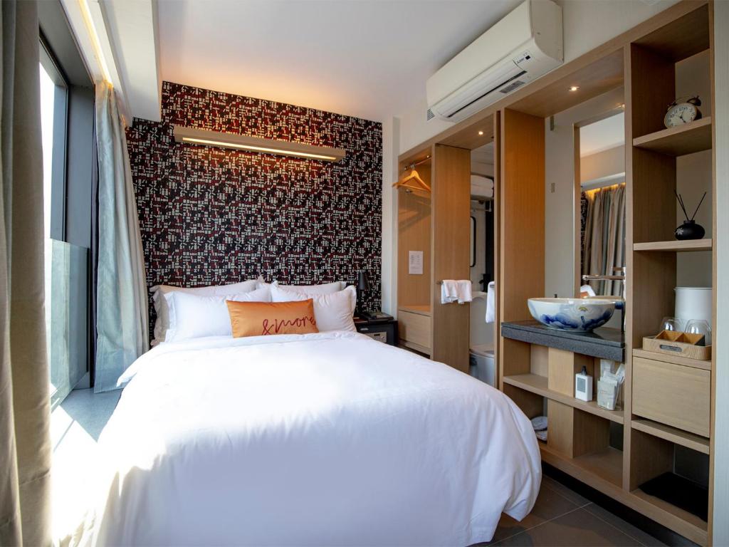 1 dormitorio con cama blanca y pared de ladrillo en Belive&More en Macao