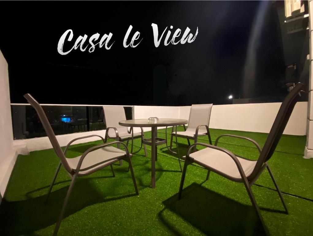 a group of chairs and a table with green grass at Casa Le View in Kuah