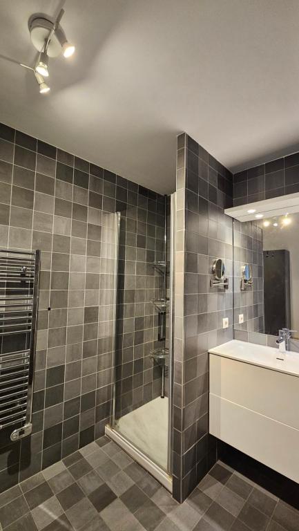 La salle de bains est pourvue d'une douche, d'un lavabo et d'une baignoire. dans l'établissement Arbre Blanc, une folie montpelliéraine, à Montpellier