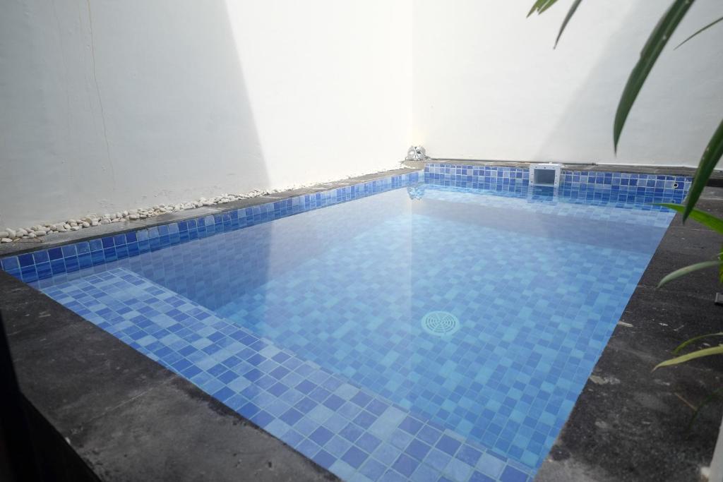 einen Pool mit blauen Bodenfliesen in der Unterkunft The Lavana Valvilla in Timuran