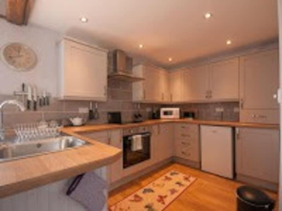 a kitchen with white cabinets and a sink at Little Rigg Cottage in Pickering