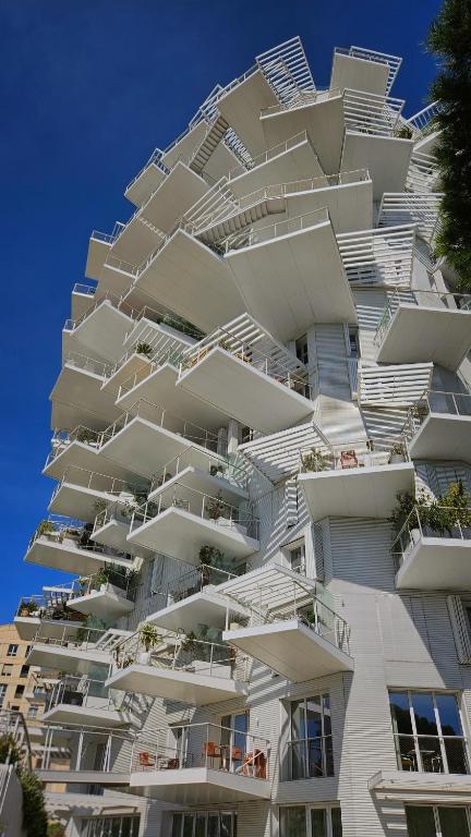 un bâtiment blanc avec des balcons sur le côté dans l'établissement Arbre Blanc, une folie montpelliéraine, à Montpellier
