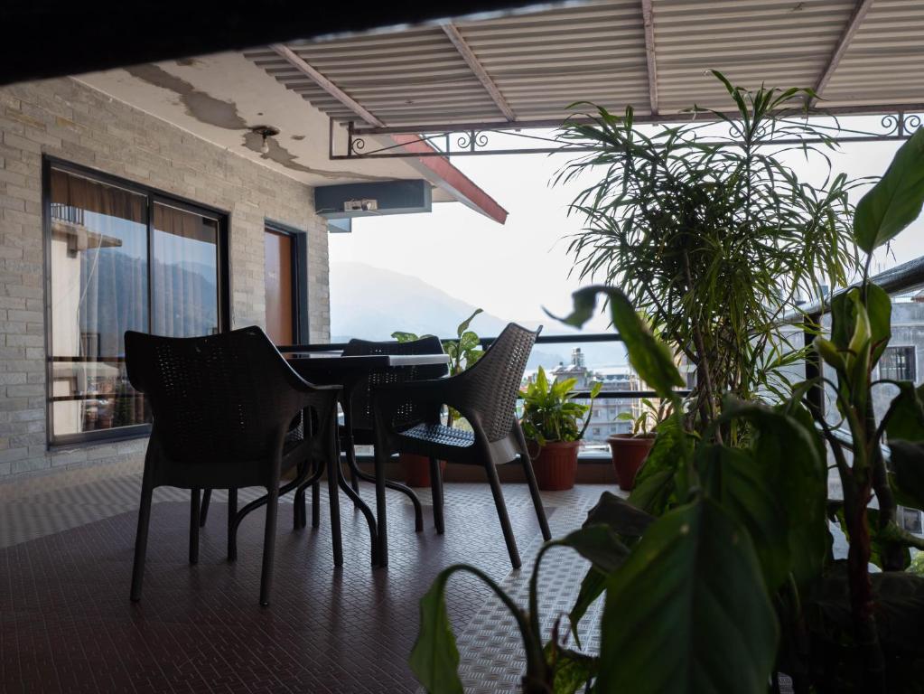 un tavolo e sedie su un balcone con piante di The North Face Inn a Pokhara