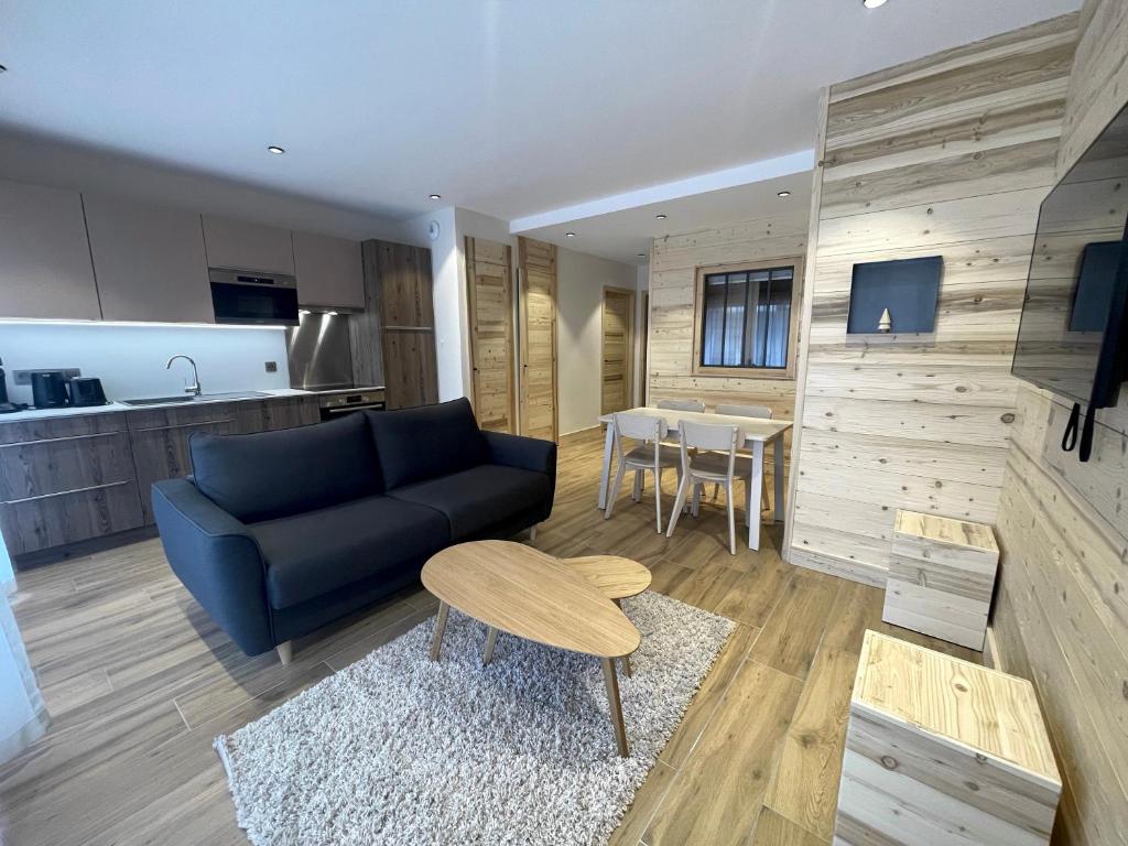 un salon avec un canapé bleu et une table dans l'établissement PETITE OURSE - Centre village et proche pistes, à La Clusaz