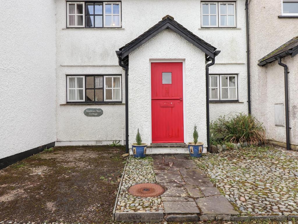una puerta roja en una casa blanca en Swallows Nest Cottage, en Ambleside