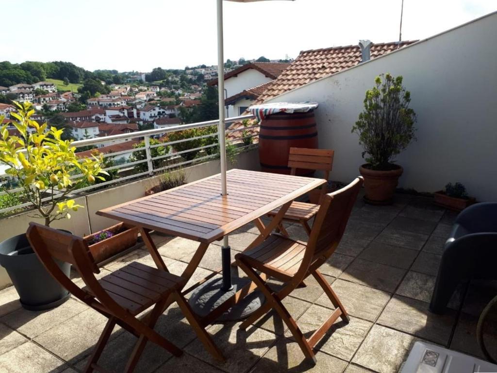 アンダイエにあるAppartement Hendaye, 2 pièces, 4 personnes - FR-1-2-302の木製テーブルと椅子付きのバルコニー