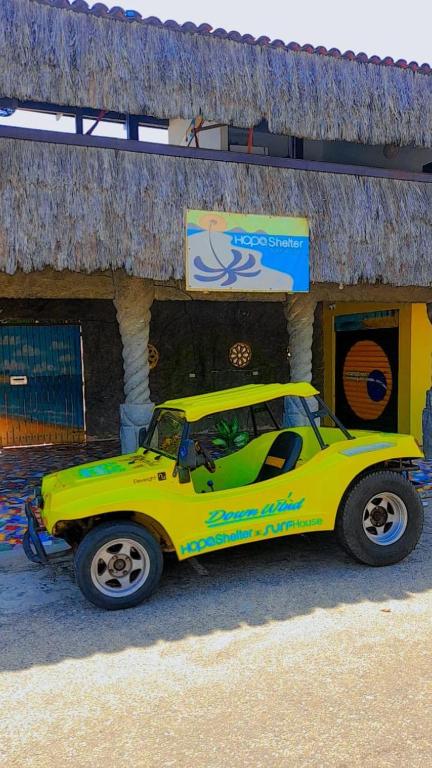 a yellow car parked in front of a building at Hopa Shelter Surf House Apartamento in Paracuru