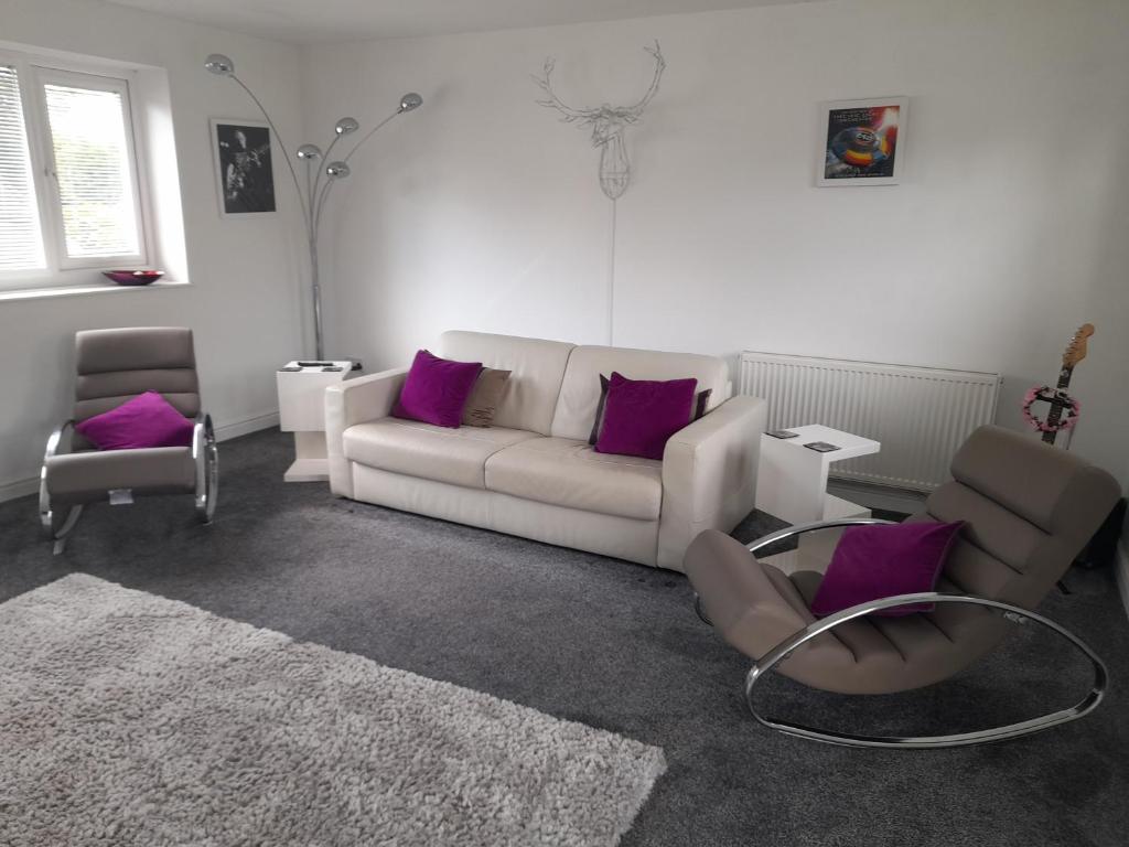 sala de estar con sofá blanco y almohadas moradas en Hawarden near Chester, en Hawarden