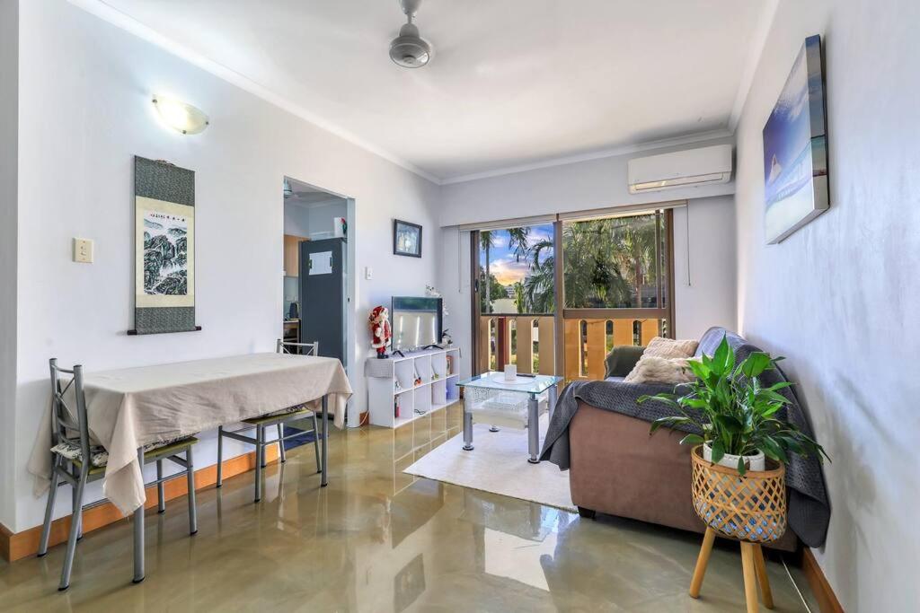 a living room with a table and a couch at Joyful Esplanade City Stay in Darwin