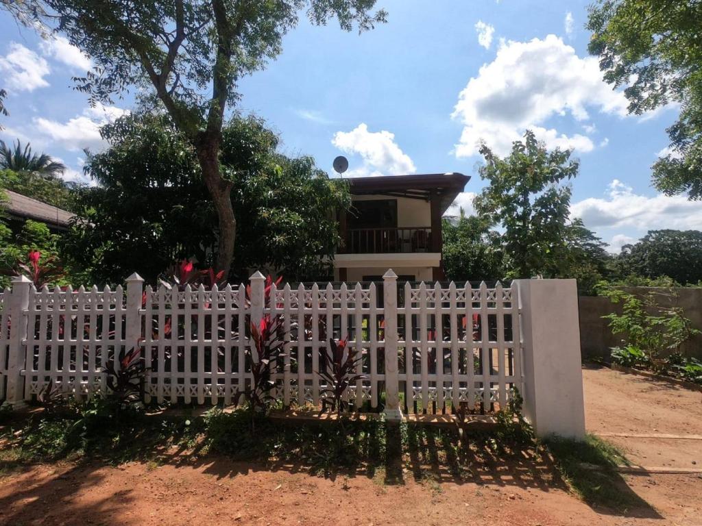 a white picket fence in front of a house at Rock View Home Stay in Dambulla