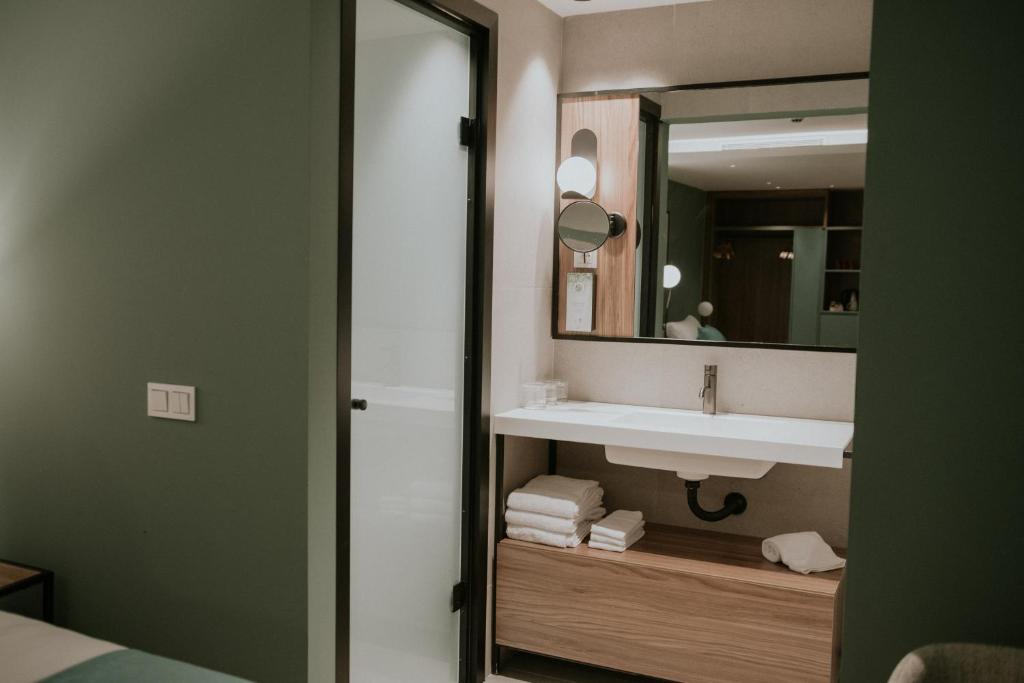 een badkamer met een wastafel en een spiegel bij Catalina Plaza Hotel Sostenible in Las Palmas de Gran Canaria
