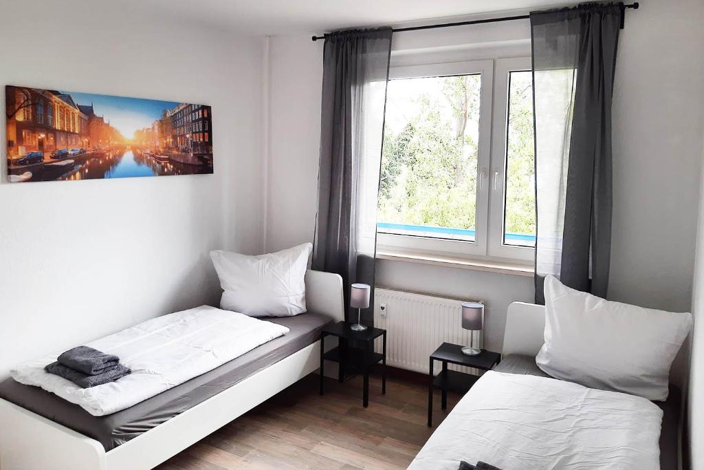 ein kleines Zimmer mit 2 Betten und einem Fenster in der Unterkunft Cozy apartments in Halle in Nietleben