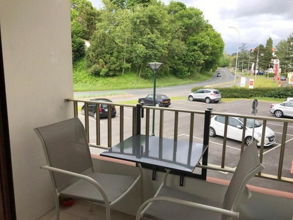 a table and chairs on a balcony with a view of a highway at Studio Saint-Jean-de-Luz, 1 pièce, 2 personnes - FR-1-4-521 in Saint-Jean-de-Luz