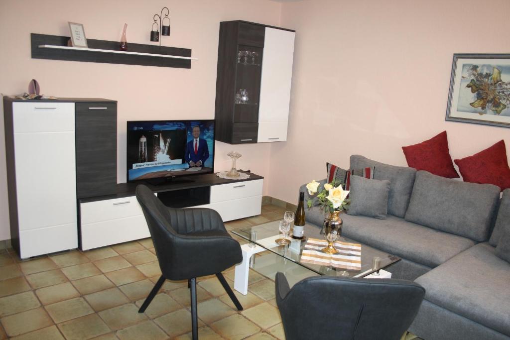 a living room with a couch and a tv at FEWO Bilstein in Lennestadt