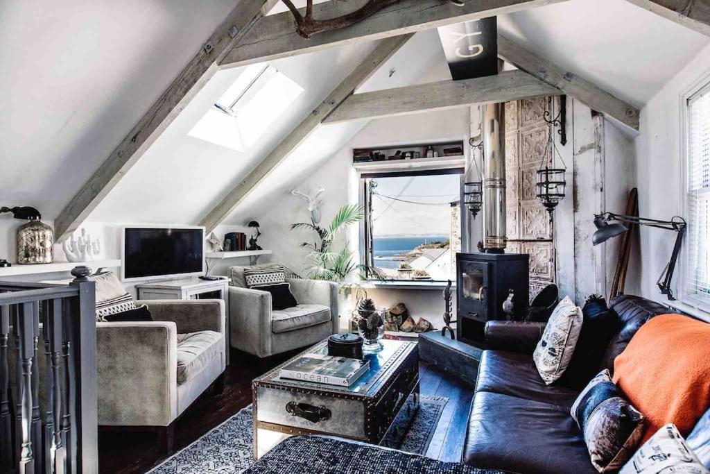 a living room with a couch and a table at The Old Stores, Luxury beach side selfcatered holiday cottage above the beach in Porthleven
