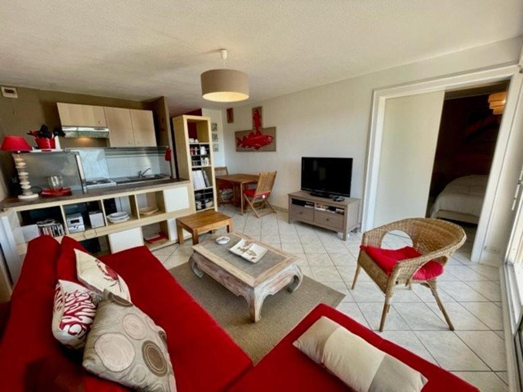 un salon avec un canapé rouge et une table dans l'établissement Appartement T2 décoré proche plage à Quiberon - FR-1-478-64, à Quiberon