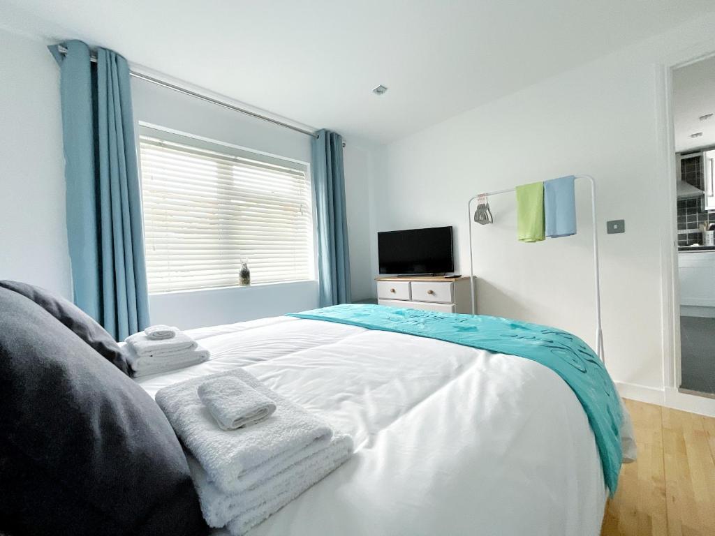 een slaapkamer met een bed met handdoeken erop bij White Eden, King bed, Free parking, Private patio, Fast WiFi, Dog, Family, Biker Friendly, Central Cornwall in St Austell
