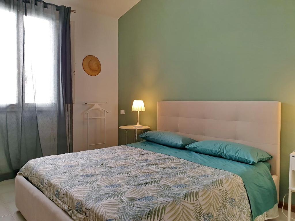a bedroom with a bed with blue pillows and a window at Casetta Donatello in Marina di Pietrasanta