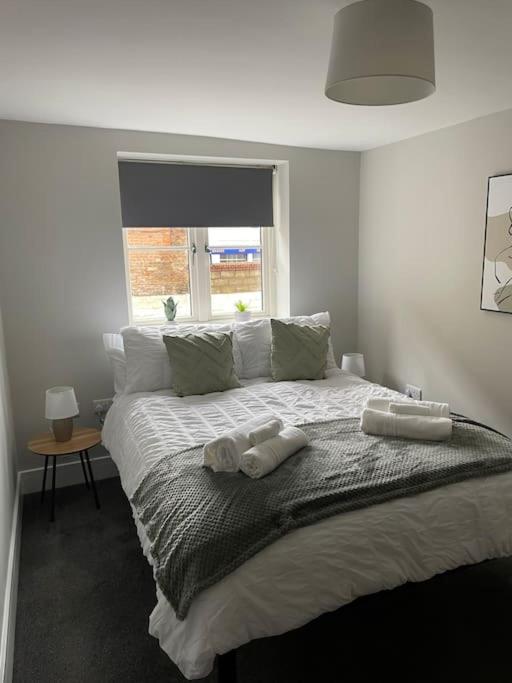 a bedroom with a bed with two towels on it at Cedar House by ShortStays4U A modern 2 bedroom house with free parking in town centre! in King's Lynn