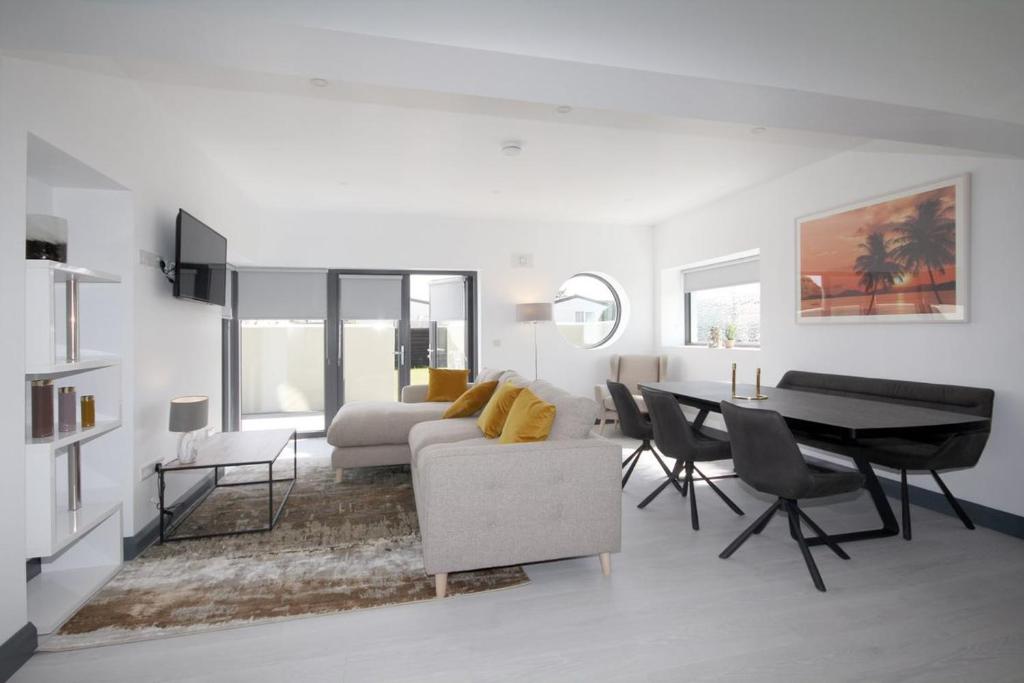 a white living room with a table and a couch at Burrow Park Holiday Apartments in Rosslare