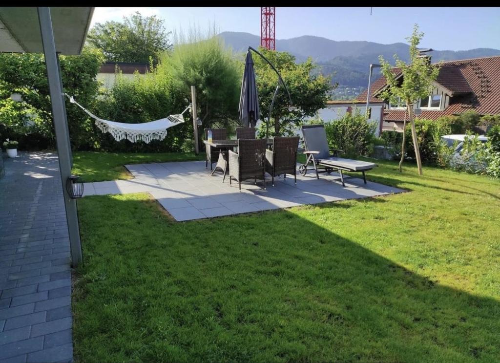 un patio trasero con hamaca, mesa y sillas en Haus Albi, en Waldkirch