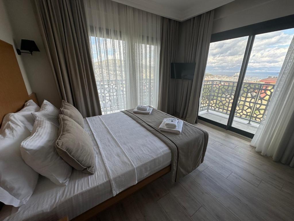 Cette chambre comprend un lit et une grande fenêtre. dans l'établissement Nova Butik Hotel Çeşme, à Çeşme