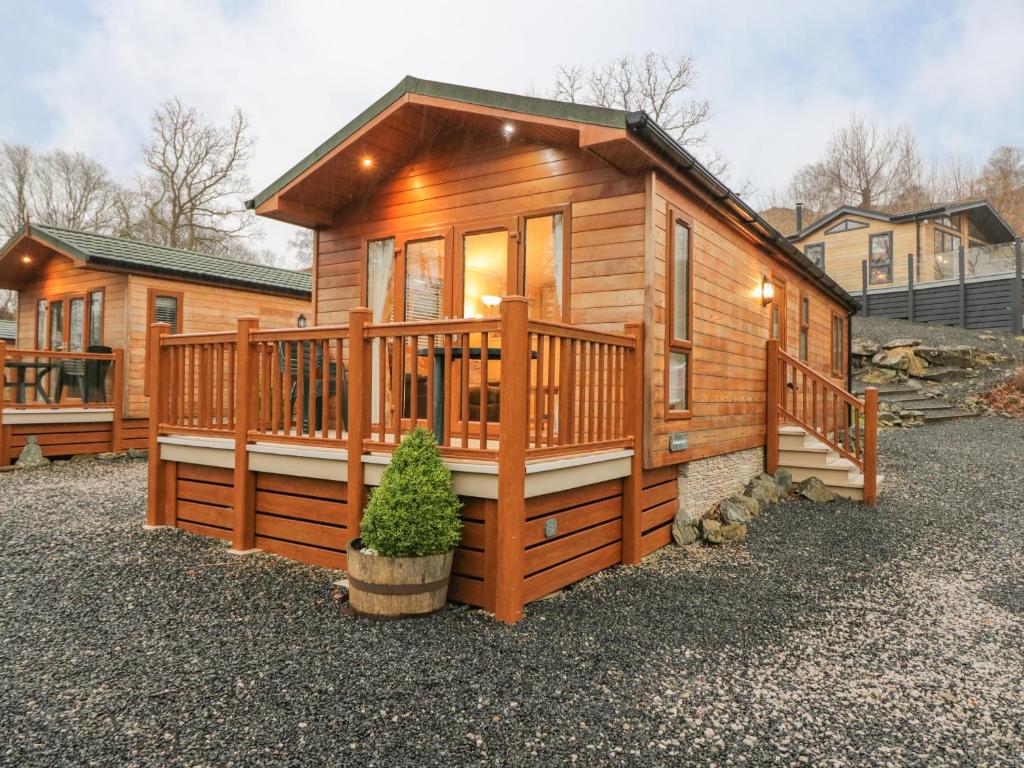 a large wooden cabin with a large deck at 8 Woodlands in Ulverston