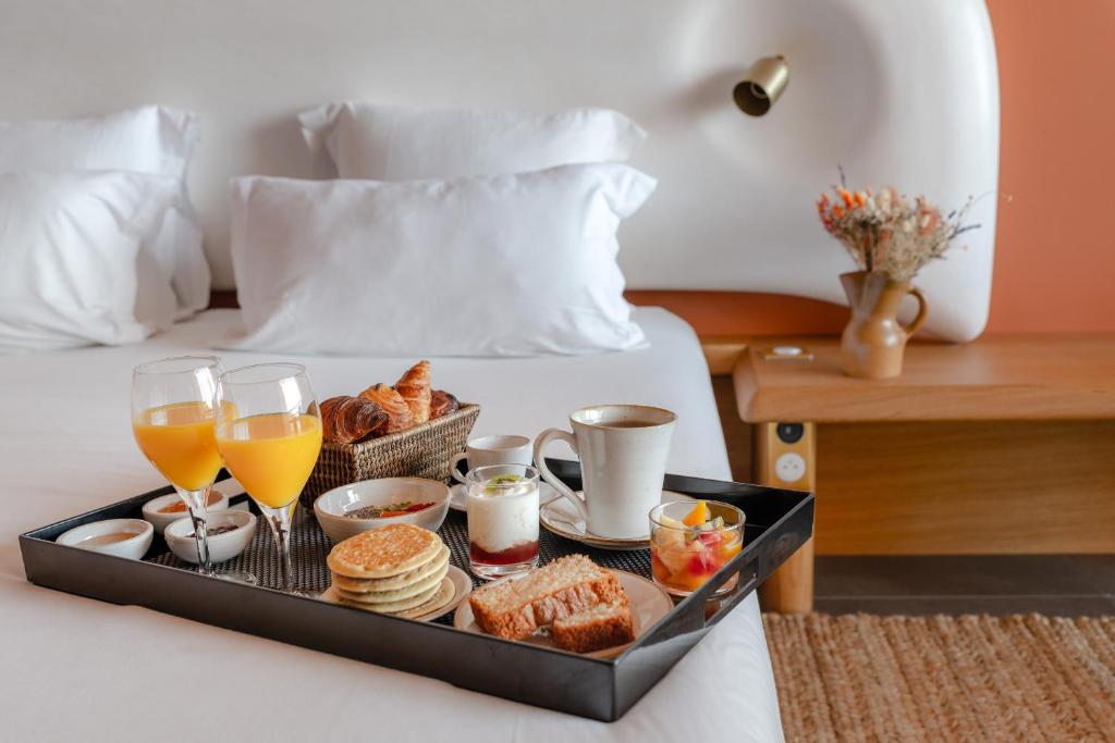 a tray of breakfast foods and drinks on a bed at Les Terrasses du Bailli in Rayol-Canadel-sur-Mer