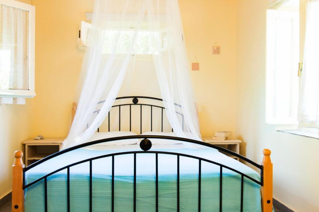 a bedroom with a bed with a canopy at Drakos Vacation Houses in Stoupa