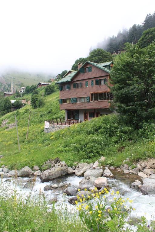 a house on a hill next to a river at Dagevi Butik Apart in Uzungöl