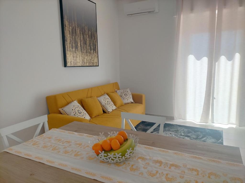 ein Wohnzimmer mit einem Sofa und einem Tisch mit Orangen darauf in der Unterkunft Holiday House Chiara in SantʼAntìoco