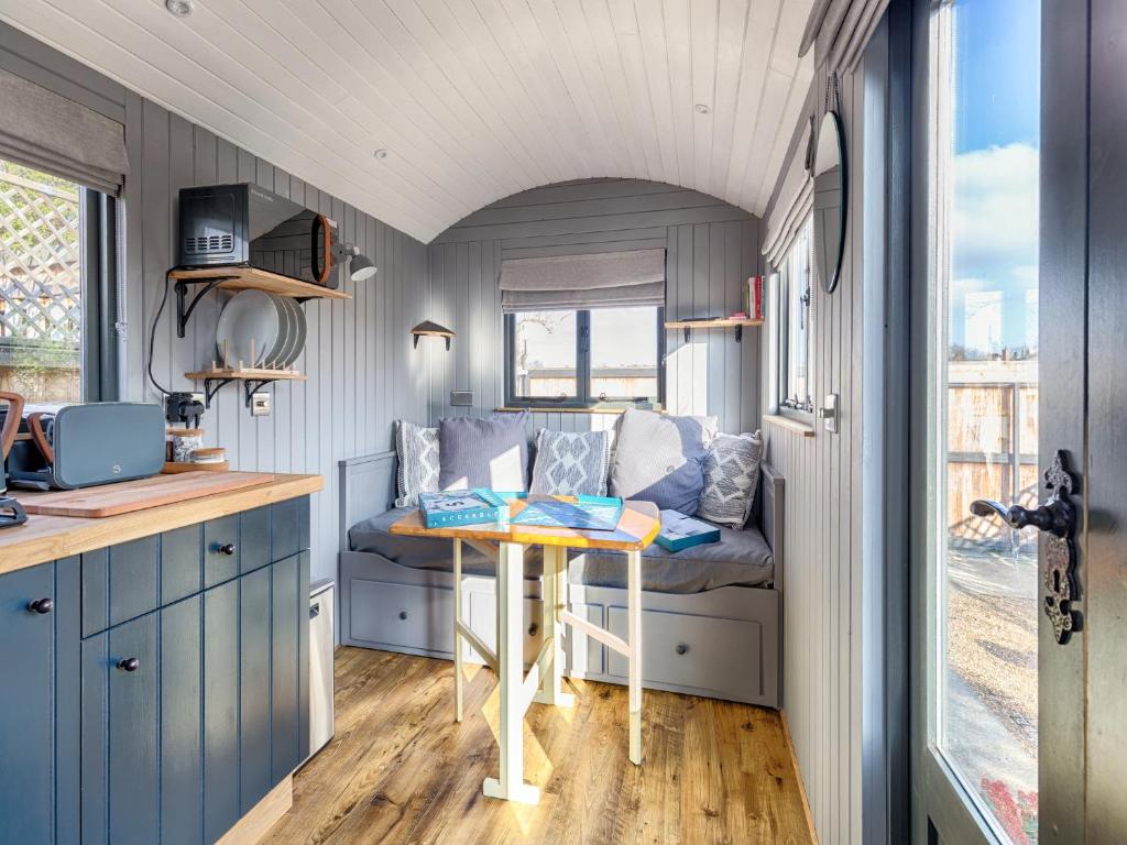 a small kitchen with a table in a tiny house at Pass the Keys Whitstable Shepherds Hut minutes from the Harbour in Whitstable