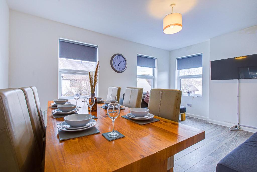 a dining room with a table with chairs and a clock at Pass the Keys City beach flat next to the sea sleeps up to 6 in Southend-on-Sea