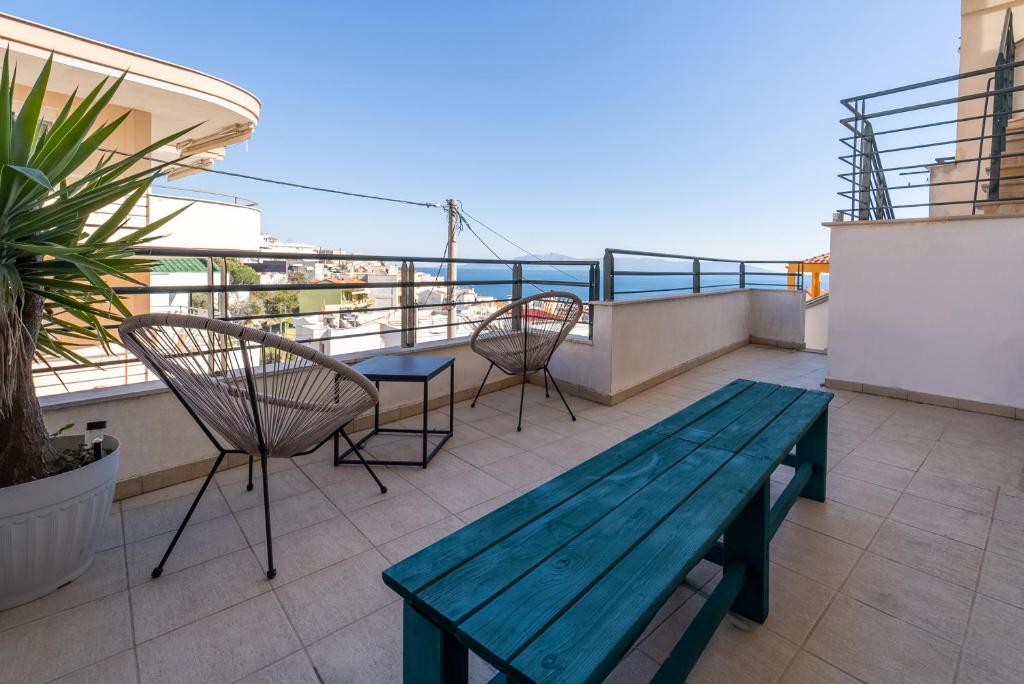 un patio avec un banc et des chaises en bois sur un balcon dans l'établissement Stay Fly, à Kavala