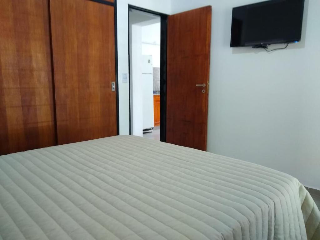 1 dormitorio con 1 cama y TV de pantalla plana en El Andaluz en San Marcos Sierras