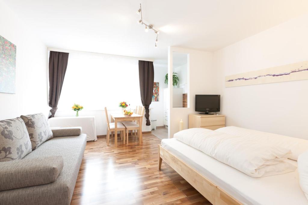 ein Wohnzimmer mit einem Bett und einem Sofa in der Unterkunft Rafael Kaiser - Apartment Cityflow in Graz