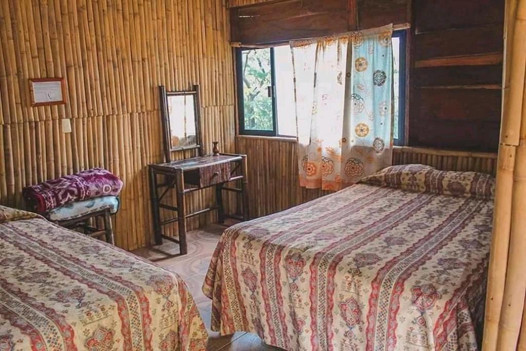 a room with two beds and a sink and a mirror at Cabañas cascadas encantadas in Catemaco