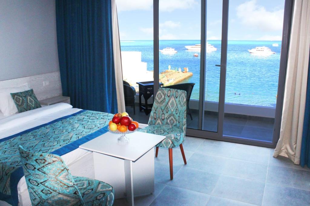 um quarto de hotel com uma cama e vista para o oceano em Shellghada Blue Beach em Hurghada