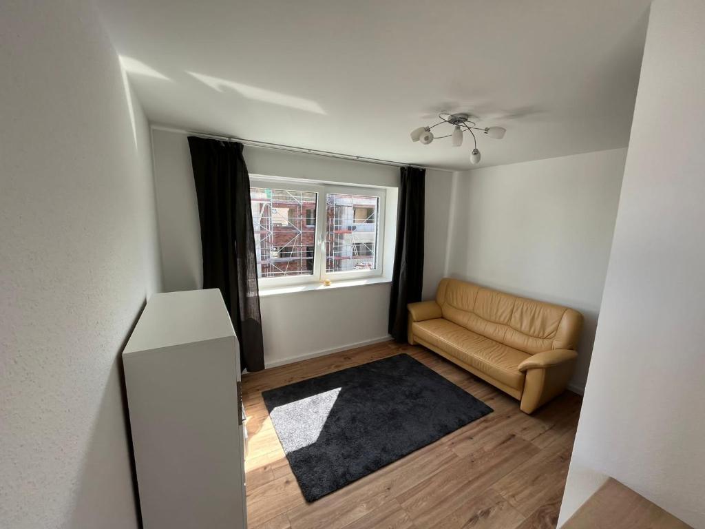 ein Wohnzimmer mit einem Sofa und einem Fenster in der Unterkunft Klytti‘s Pension in Sendenhorst