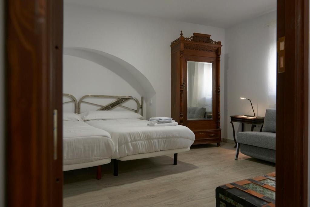 a bedroom with a bed and a mirror and a chair at Casona Alcarria in Pastrana