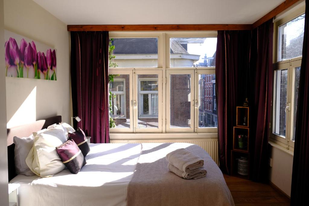 1 dormitorio con cama blanca y ventana en Eelhouse private studio en Ámsterdam