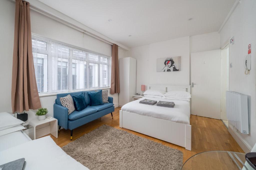 - une chambre avec un lit et une chaise bleue dans l'établissement Private Studio - Wardour Street - Berwick Street, à Londres