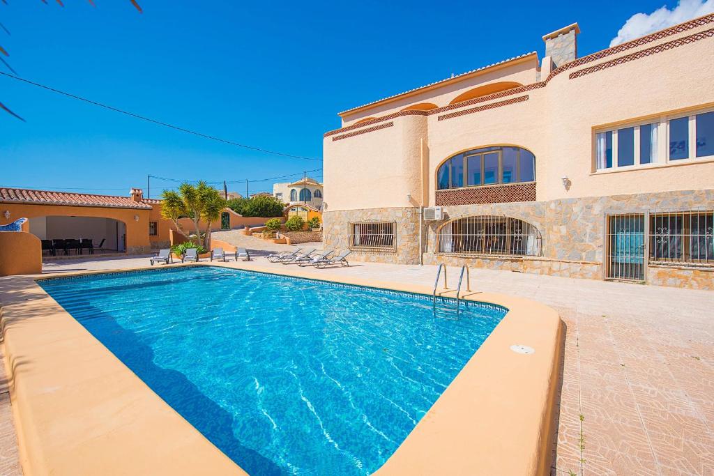 a swimming pool in front of a house at Villa Cronos - PlusHolidays in Calpe